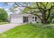 Charming ranch-style home with brick facade, attached garage, and mature landscaping at 7345 Monon Cir, Indianapolis, IN 46256