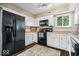 Well-lit kitchen with white cabinets, black appliances, and a stylish rug at 7345 Monon Cir, Indianapolis, IN 46256