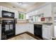 Charming kitchen featuring white cabinets, black appliances, and a window over the sink at 7345 Monon Cir, Indianapolis, IN 46256