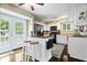 Bright kitchen with white cabinets, black appliances, breakfast bar, and view to the backyard at 7345 Monon Cir, Indianapolis, IN 46256