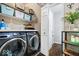Well-organized laundry room with front loading washer and dryer, shelving and open door to powder room at 7345 Monon Cir, Indianapolis, IN 46256