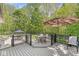 A spacious backyard deck with a table and umbrella surrounded by trees at 7421 Meadow Violet Ct, Avon, IN 46123