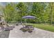 A backyard with a large stone patio, table and chairs, and lush foliage at 7421 Meadow Violet Ct, Avon, IN 46123