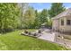 The large backyard with a stone patio, furniture, and lush landscaping at 7421 Meadow Violet Ct, Avon, IN 46123