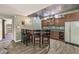 Basement bar area with wood cabinets, bar seating, and adjacent shelving at 7421 Meadow Violet Ct, Avon, IN 46123