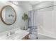Well-lit bathroom featuring a white vanity, wooden-trimmed mirror, and shower-tub combination at 7421 Meadow Violet Ct, Avon, IN 46123