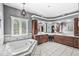Relaxing bathroom with a large soaking tub, dual vanity, modern fixtures, and tile floors at 7421 Meadow Violet Ct, Avon, IN 46123