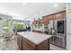 Open concept kitchen featuring stainless steel appliances and island with seating with views to the dining and living area at 7421 Meadow Violet Ct, Avon, IN 46123