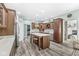 Kitchen featuring stainless steel appliances, island with seating, hardwood floors, and light countertops at 7421 Meadow Violet Ct, Avon, IN 46123