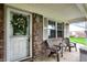 Cozy front porch featuring seating, a charming 'welcome' wreath on the door, and a well-kept brick exterior at 7840 Park Ward Pl, Indianapolis, IN 46259