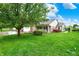 Beautifully landscaped front yard with mature trees and a well-maintained lawn leading up to a brick-and-vinyl home at 7840 Park Ward Pl, Indianapolis, IN 46259