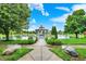 Picturesque gazebo overlooking a serene pond, framed by lush landscaping and a clear blue sky with fluffy clouds at 7840 Park Ward Pl, Indianapolis, IN 46259