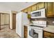 Kitchen featuring white appliances, wooden cabinets, and view to another room at 7840 Park Ward Pl, Indianapolis, IN 46259