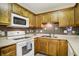Kitchen area showcasing wooden cabinets, tile backsplash, and white appliances at 7840 Park Ward Pl, Indianapolis, IN 46259