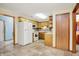 Kitchen featuring white appliances, wooden cabinets, and tile flooring leading to other spaces at 7840 Park Ward Pl, Indianapolis, IN 46259