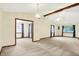 Spacious living room featuring vaulted ceilings, exposed beams, modern lighting, and neutral carpeting at 7840 Park Ward Pl, Indianapolis, IN 46259