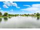 Scenic view of a pond with a fountain, surrounded by well-maintained lawns and mature trees under a clear blue sky at 7840 Park Ward Pl, Indianapolis, IN 46259
