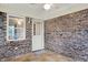 Enclosed porch with brick walls, tile floor, windows, and a view of the backyard, ideal for relaxation at 7840 Park Ward Pl, Indianapolis, IN 46259