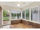 Charming sunroom with brick accents, tile flooring, and natural light through large windows and sliding doors at 7840 Park Ward Pl, Indianapolis, IN 46259