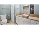 Contemporary bathroom with a vessel sink, wood countertop, white cabinets, and modern toilet at 7910 Teel Way, Indianapolis, IN 46256