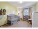 A cozy Bedroom with a gray crib, bookcase, and window, creating a comforting and welcoming space at 7910 Teel Way, Indianapolis, IN 46256