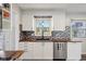 Well-lit kitchen showcasing white cabinets, butcher block counters, stainless steel appliances, and a window above the sink at 7910 Teel Way, Indianapolis, IN 46256