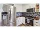 Close up of updated kitchen with stainless steel refrigerator, stove, microwave and white cabinets at 7910 Teel Way, Indianapolis, IN 46256