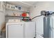 Laundry room with washer, dryer, shelving, and water filtration system at 7910 Teel Way, Indianapolis, IN 46256