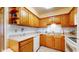 Functional kitchen features wood cabinetry, white countertops, and essential appliances for easy meal preparation at 7937 Bentley Commons Dr, Indianapolis, IN 46259