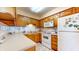 Traditional-style kitchen with white appliances and wood cabinets provides a warm and inviting space at 7937 Bentley Commons Dr, Indianapolis, IN 46259