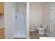 Bright bathroom features a walk-in shower, neutral tile floor, toilet with assistive handle, and wooden cabinets at 8133 Hazen Way, Indianapolis, IN 46216