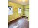 Empty bedroom featuring two windows, closet, and damaged floors at 834 N Temple Ave, Indianapolis, IN 46201