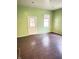 Empty living room with green walls, and dark hard wood floors at 834 N Temple Ave, Indianapolis, IN 46201