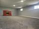 Finished basement with gray carpet, red brick fireplace, and natural light at 8417 S Sherman Dr, Indianapolis, IN 46237