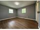 A view of the bedroom with wood-look flooring and two windows at 8417 S Sherman Dr, Indianapolis, IN 46237