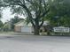 A street view of a charming tan brick ranch home with a two car garage and neighborhood signage at 8417 S Sherman Dr, Indianapolis, IN 46237