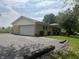Tan brick ranch style home with an attached two car garage and a large paved driveway at 8417 S Sherman Dr, Indianapolis, IN 46237