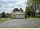 Tan brick ranch style home with an attached two car garage and an asphalt driveway at 8417 S Sherman Dr, Indianapolis, IN 46237