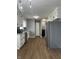 Remodeled kitchen featuring white cabinets, gray walls, stainless appliances, and vinyl plank flooring at 8417 S Sherman Dr, Indianapolis, IN 46237