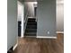 A view of the home's staircase with carpeted steps and wood-look flooring at 8417 S Sherman Dr, Indianapolis, IN 46237