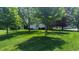 Tree-lined backyard with a well-manicured lawn providing a serene setting at 8598 Lantern Farms Dr, Fishers, IN 46038