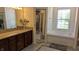 Bright bathroom featuring tile flooring, a soaking tub, and a granite-topped wood vanity at 8598 Lantern Farms Dr, Fishers, IN 46038