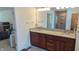 Bathroom with a double vanity featuring granite countertops, wood cabinets, and large mirrors at 8598 Lantern Farms Dr, Fishers, IN 46038