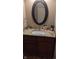 Well-appointed bathroom vanity with a sink, granite countertop, decorative mirror, and dark wood cabinetry at 8598 Lantern Farms Dr, Fishers, IN 46038