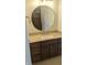 Stylish bathroom featuring a circular mirror and wood vanity with plenty of storage space at 8598 Lantern Farms Dr, Fishers, IN 46038
