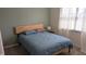 Comfortable bedroom features a wood-framed bed, soft green walls, and natural light at 8598 Lantern Farms Dr, Fishers, IN 46038