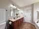 Bathroom featuring double sinks, soaking tub, shower, and vanity with dark wood cabinets at 8644 N Deer Crossing Blvd, McCordsville, IN 46055