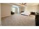 Large carpeted bedroom with chair, ceiling fan, and tray ceiling at 8644 N Deer Crossing Blvd, McCordsville, IN 46055
