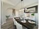 Dining room featuring hardwood floors, table seating for six, and modern decor and mirror at 8644 N Deer Crossing Blvd, McCordsville, IN 46055