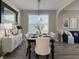 Dining room features stylish table decor, hardwood floors, and lots of natural light from the window at 8644 N Deer Crossing Blvd, McCordsville, IN 46055